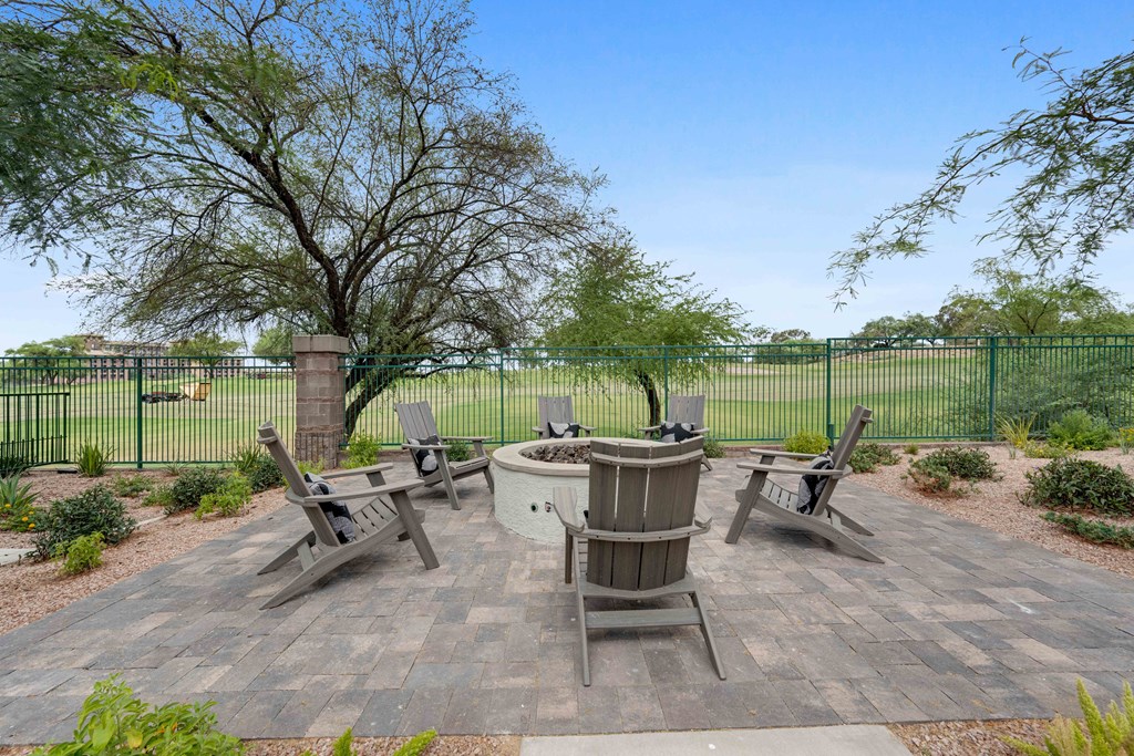 an outdoor patio with a firepit and chairs
