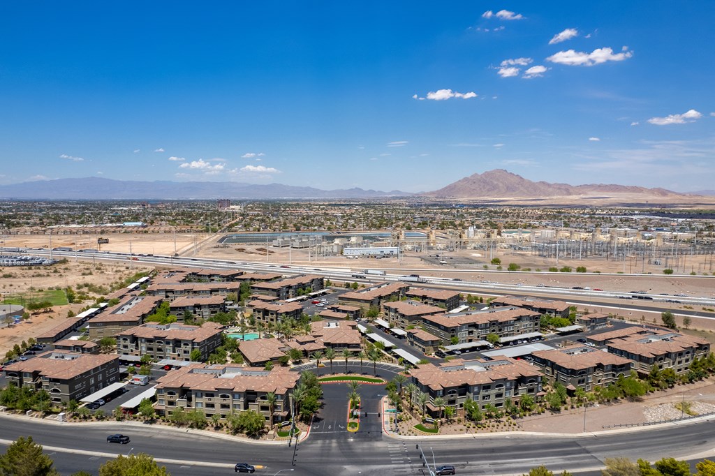 an aerial view of a neighborhood with a road and mountains in the background