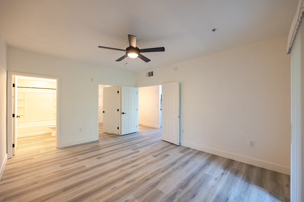 a bedroom with hardwood floors and a ceiling fan