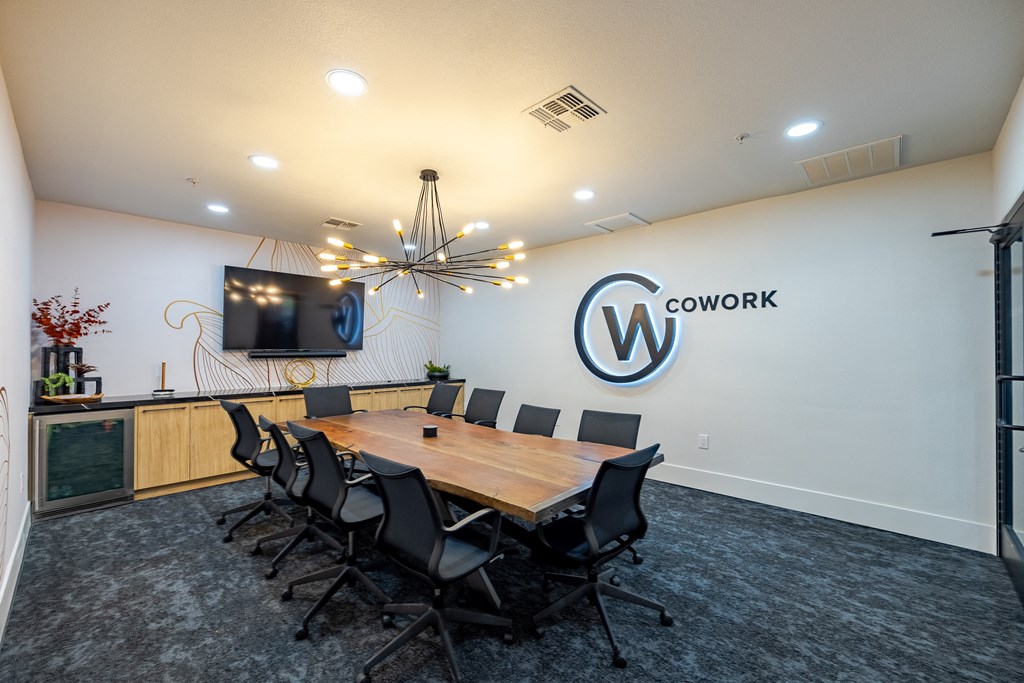 a conference room with a table and chairs and a tv on the wall