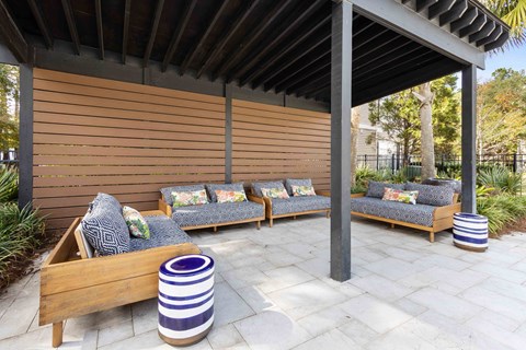 a covered patio with couches and a pergola