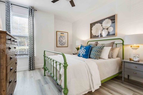 a green and white bedroom with a bed and a window