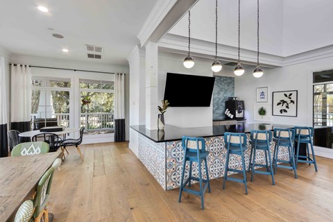 the kitchen has a large island with blue bar stools