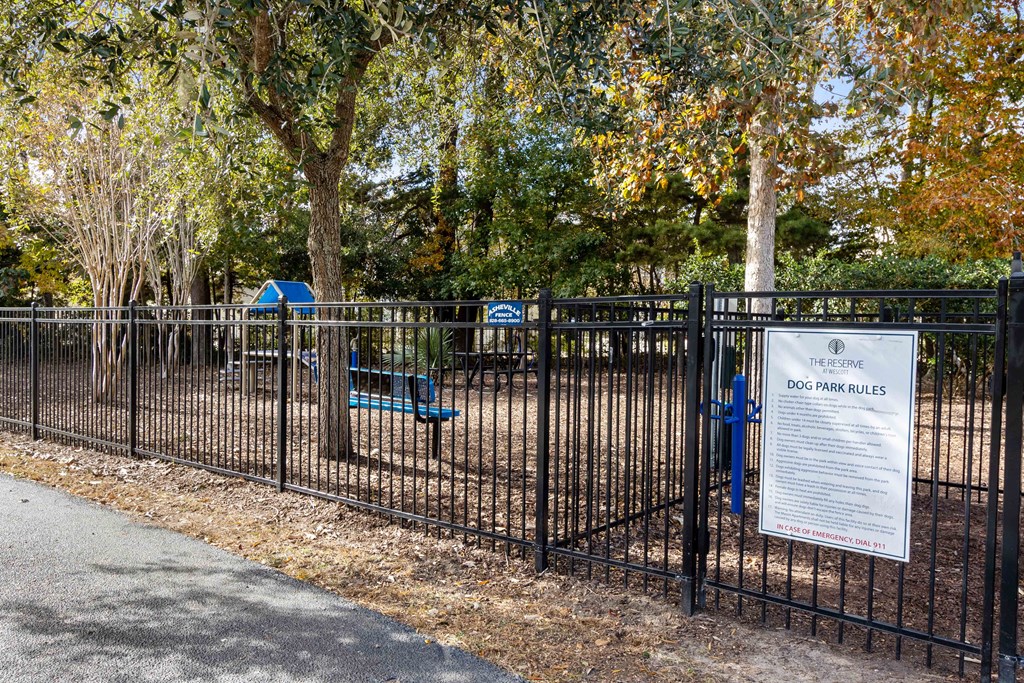 a park with a fence and a sign