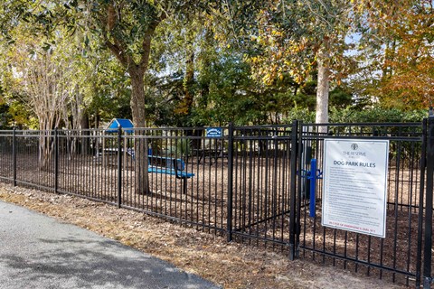 a park with a fence and a sign