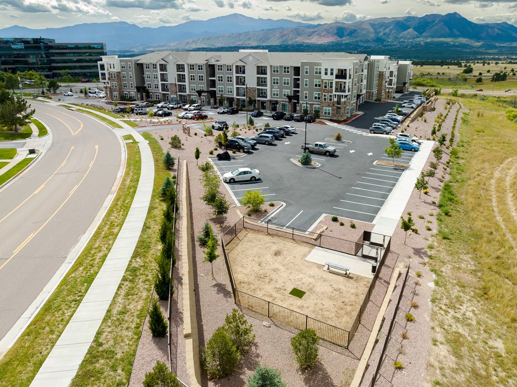 an aerial view of a parking lot in front of an apartment building