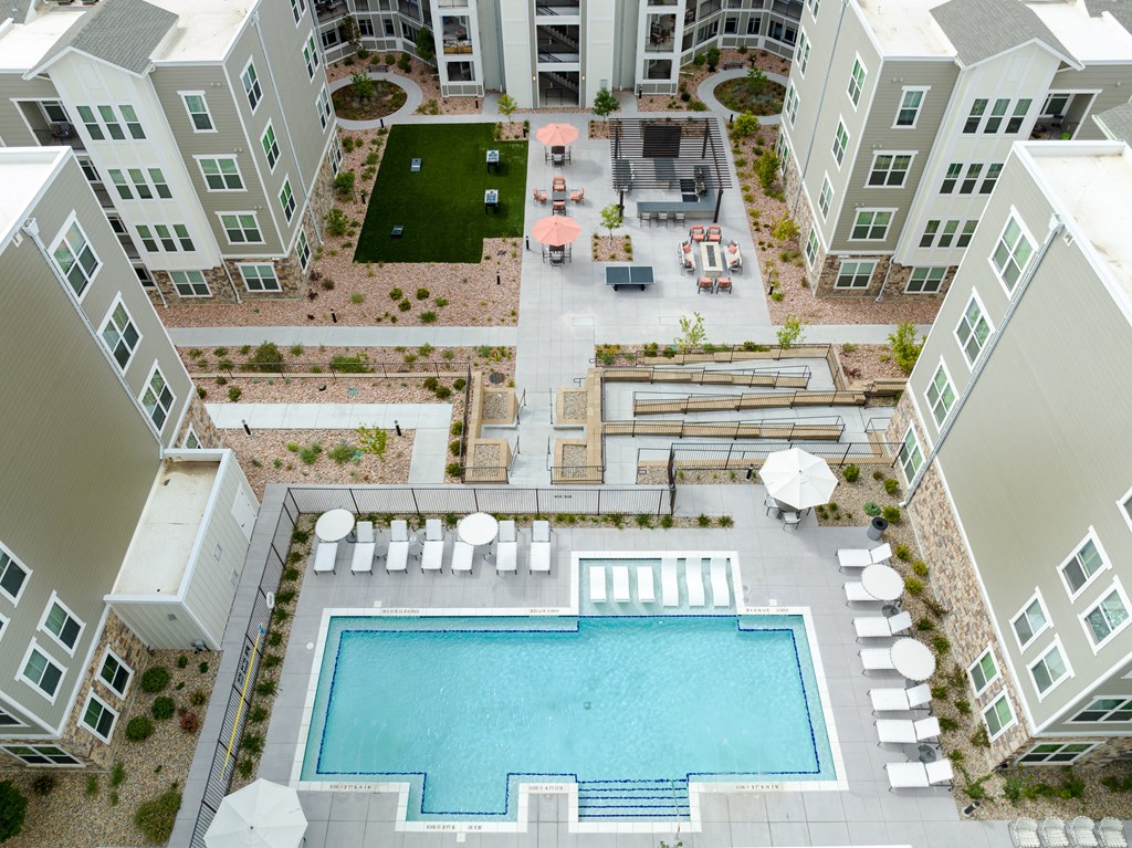 an aerial view of the zeb apartment complex with an outdoor pool and lawn