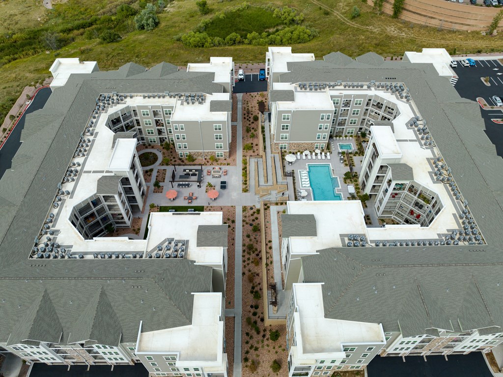 a birds eye view of a building complex with apartments and a pool in colorado springs