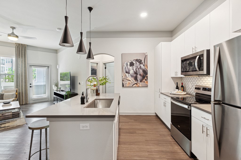 a kitchen with white cabinets and stainless steel appliances and a sink