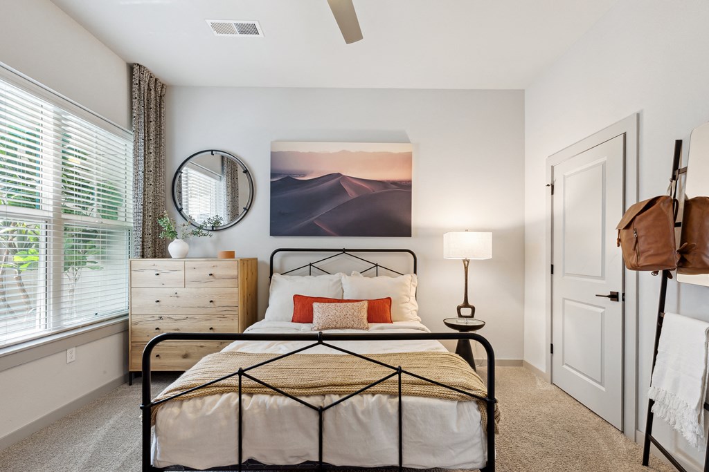 an open bedroom with a bed and a large window