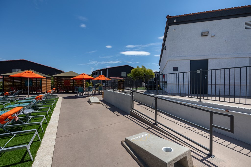 a rooftop patio with lounge chairs and umbrellas