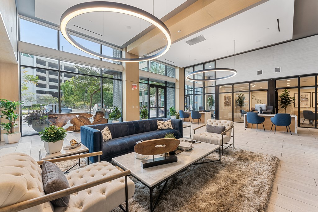 A modern living room with a large window and a variety of seating options.