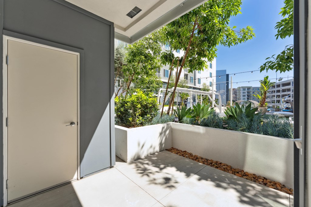 A white door is open to a balcony with a view of a cityscape.