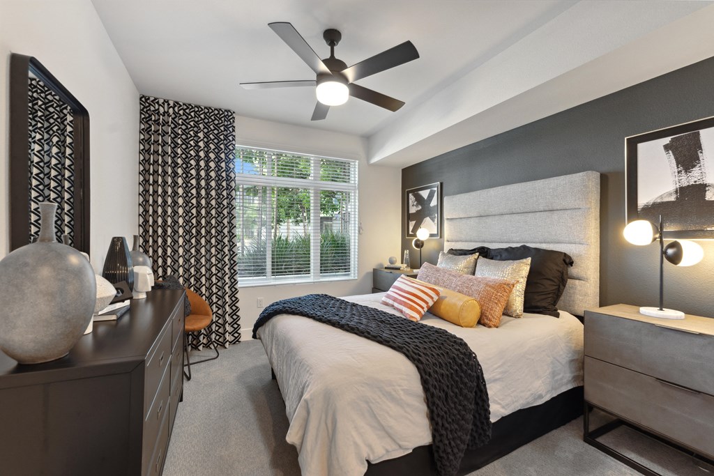 a bedroom with a large bed and a ceiling fan