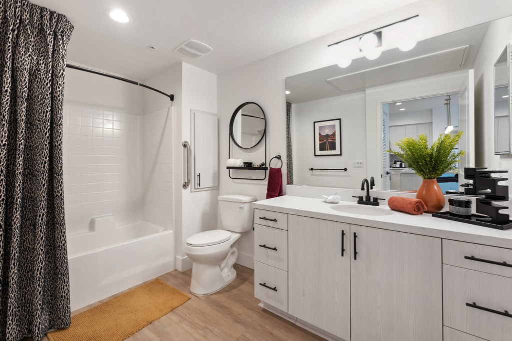 A bathroom with a white toilet, sink, and a mirror.