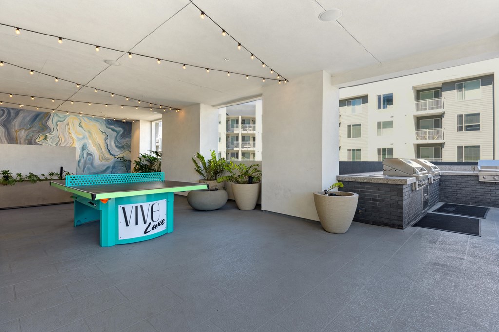 a patio with a ping pong table and a pool