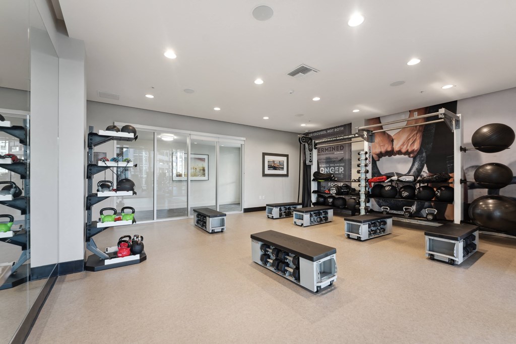 A gym with a variety of equipment including weights and machines.
