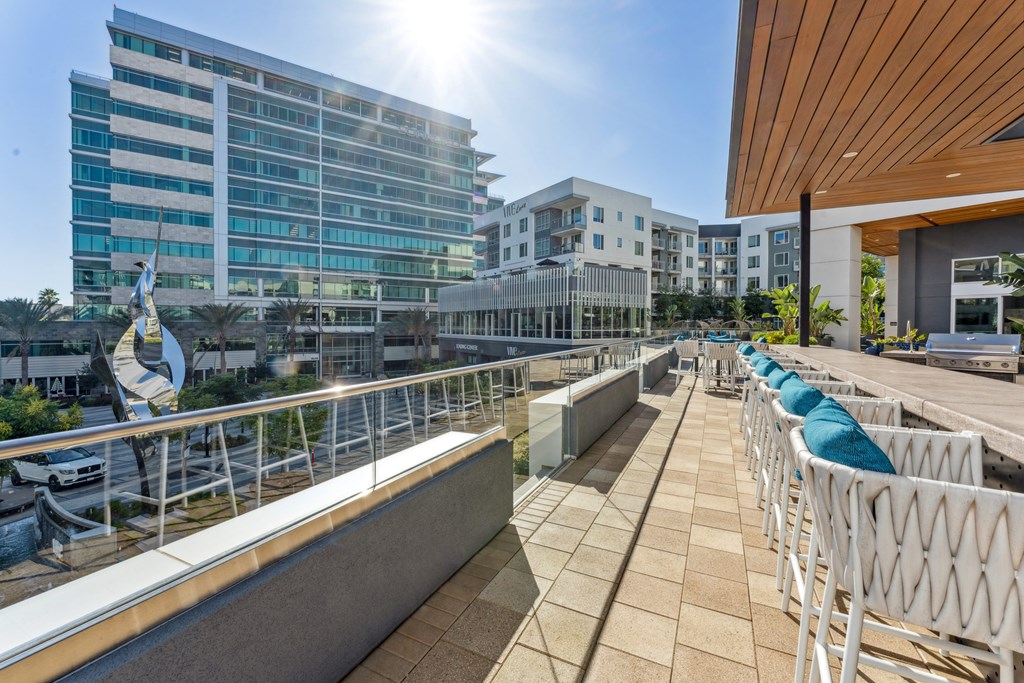 a large terrace with white chairs and a building in the background