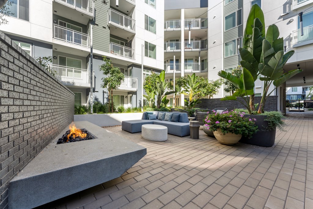 an outdoor living area with a fireplace and an apartment building