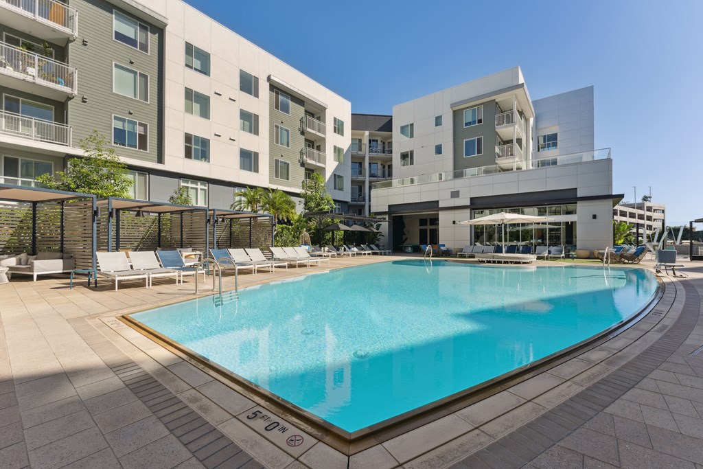 a large swimming pool in front of an apartment building
