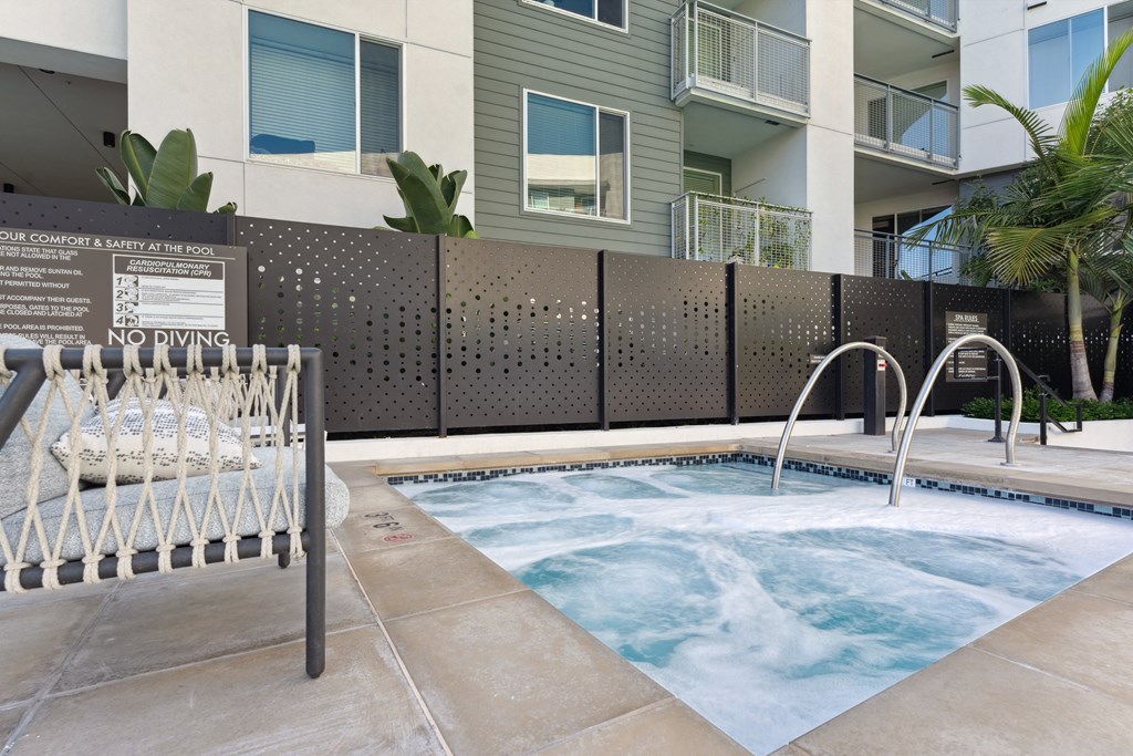 A hot tub is surrounded by a wall with a sign that reads