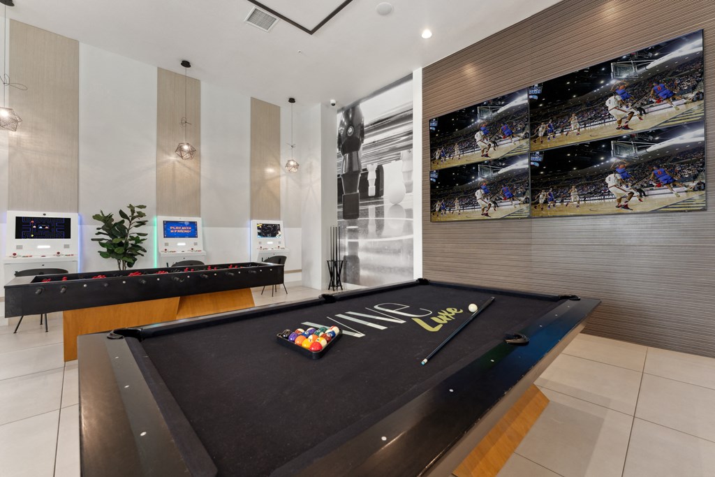 A pool table with a green felt cloth and a white cue ball and red balls.