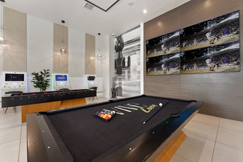 a game room with a pool table and a large scoreboard