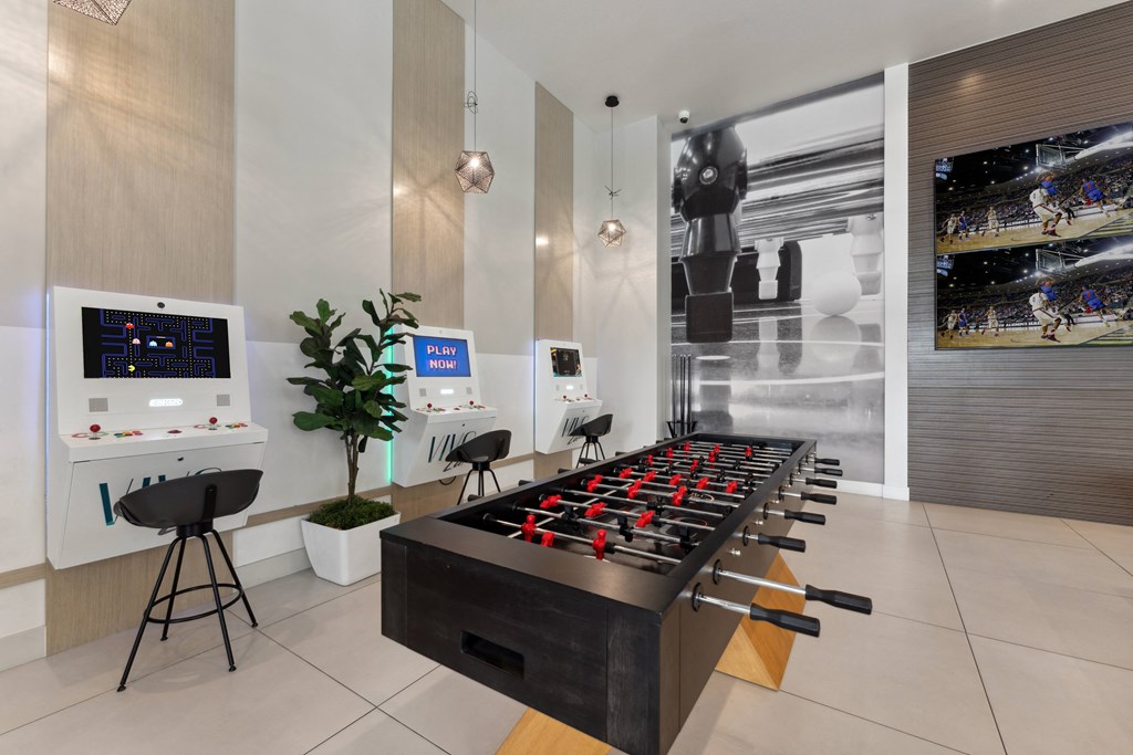 a game room with a foosball table and chairs