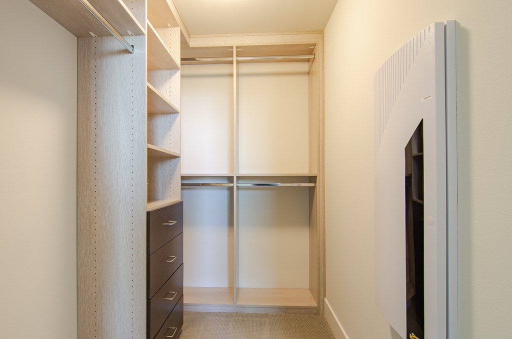 A white closet with a sliding door and a shelf.