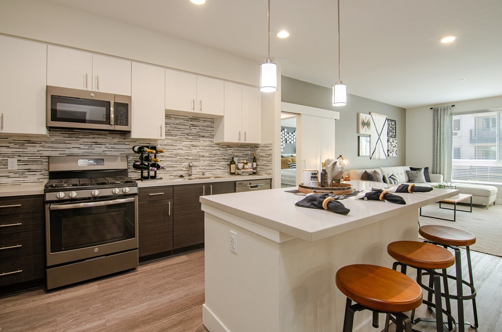 A modern kitchen with a white island and stainless steel appliances.