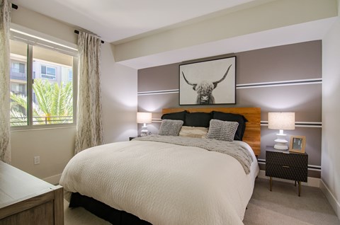 a bedroom with a large bed and two night stands with lamps