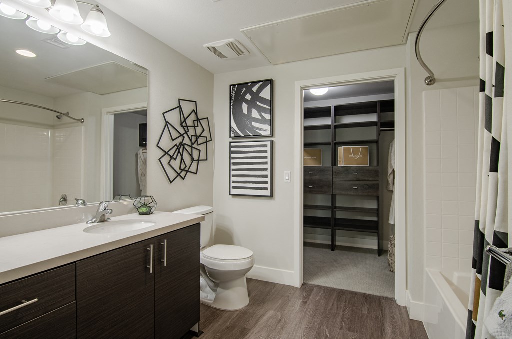 A bathroom with a toilet, sink, and a mirror.
