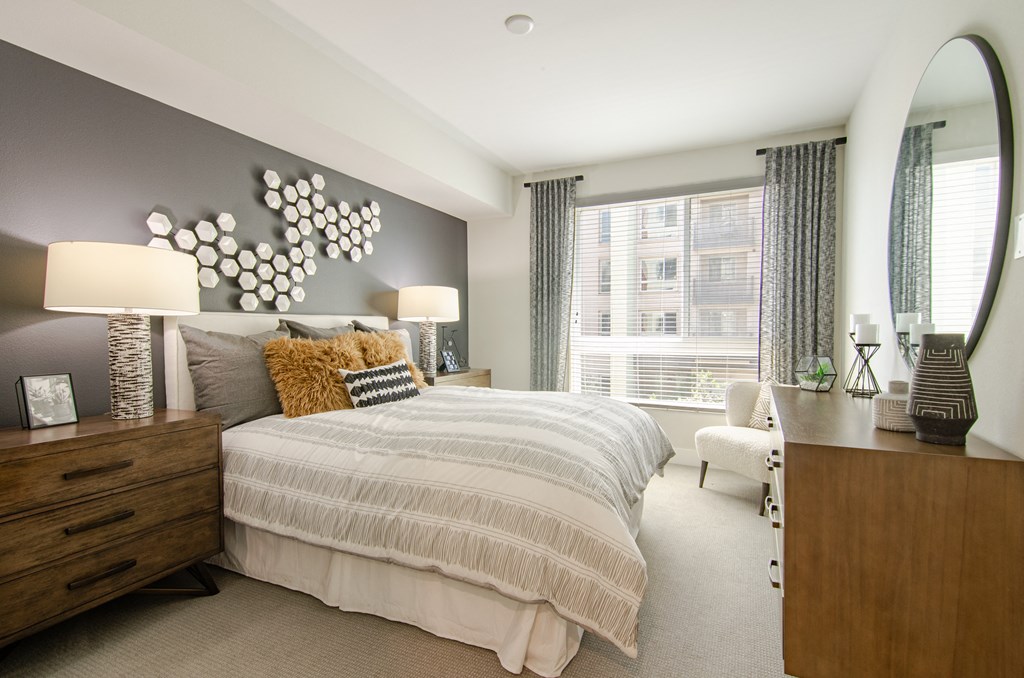 A bedroom with a large bed and a mirror on the wall.