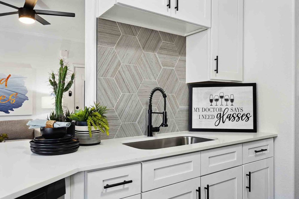 a kitchen with white cabinets and a white sink