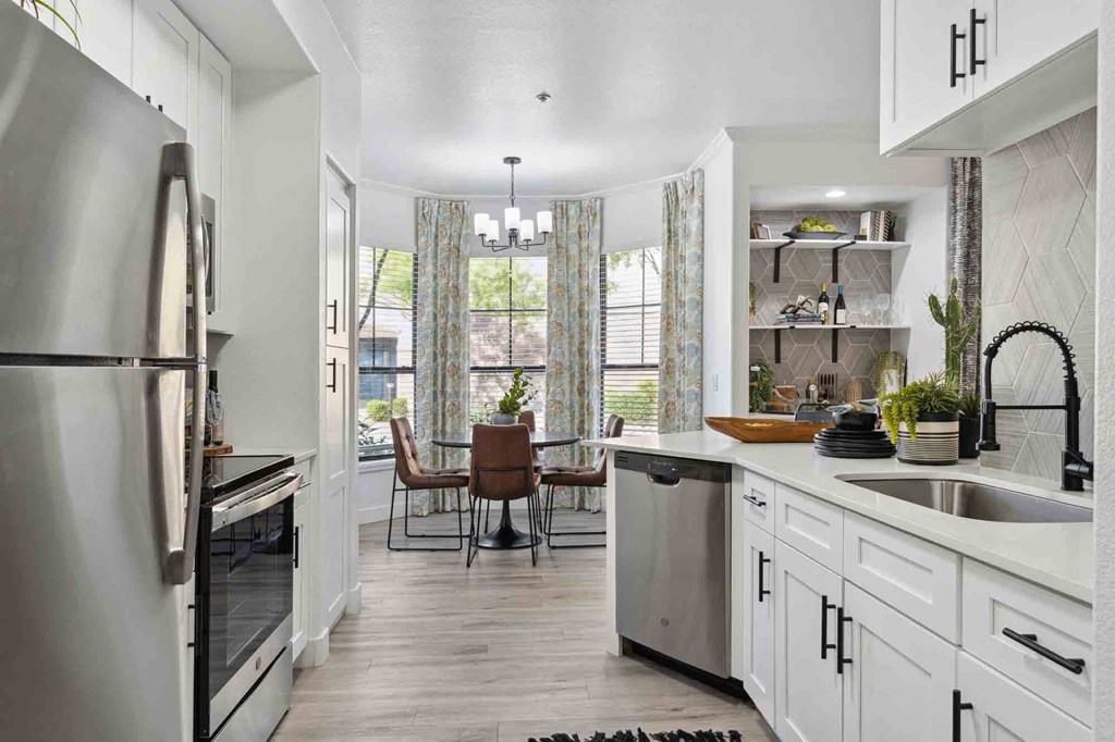 Kitchen with stainless appliances and a view to the in-kitchen dining area at Zone Apartments complexes in Glendale, AZ.