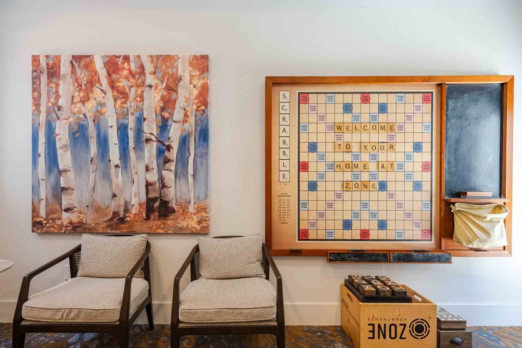 a room with two chairs and a scrabble board on the wall