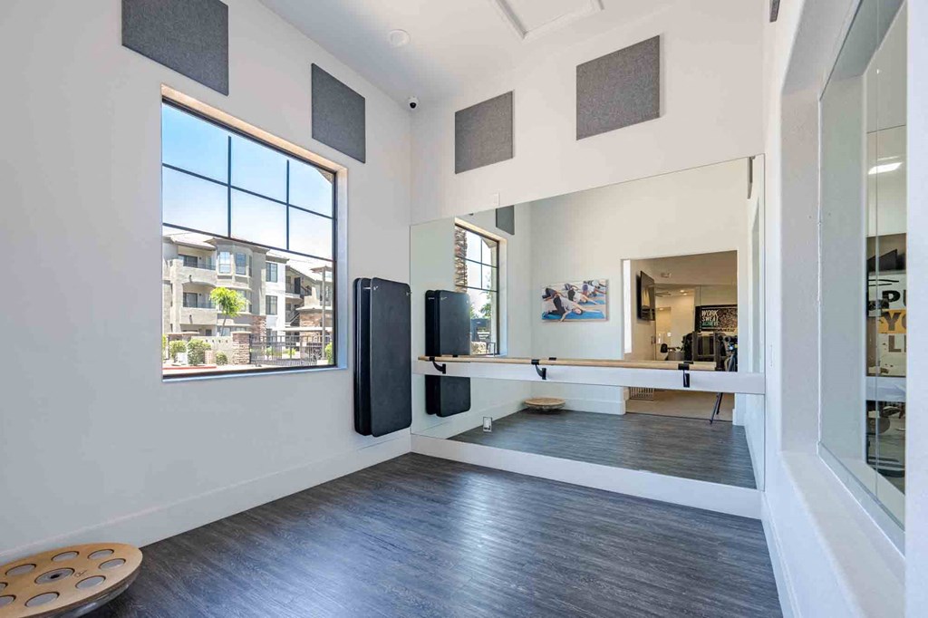 a home gym with a large window and hardwood floors