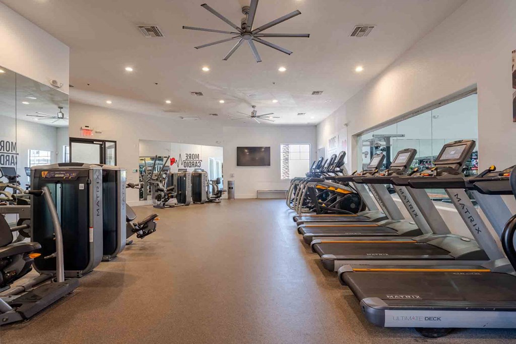 a spacious fitness center with cardio machines and other exercise equipment