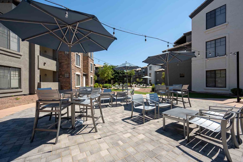 patio with tables and chairs and umbrellas at the residences at silver hill in suitland