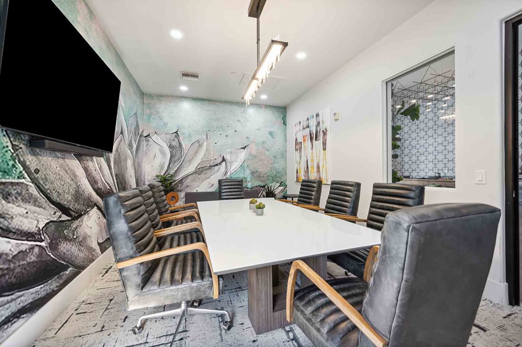 a meeting room with a white table and chairs and a large mural on the wall