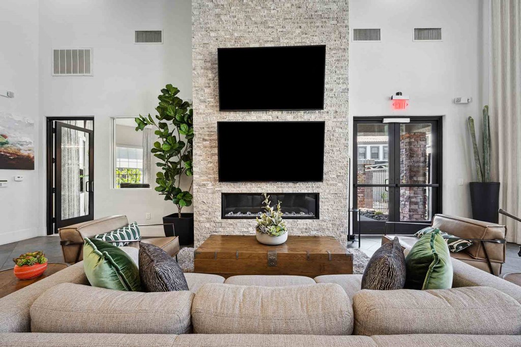 a living room with couches and a coffee table in front of a fireplace