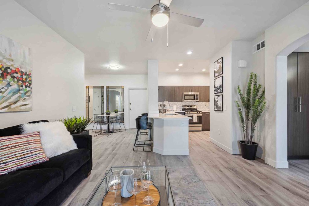 a living room with a couch and a coffee table in front of a kitchen