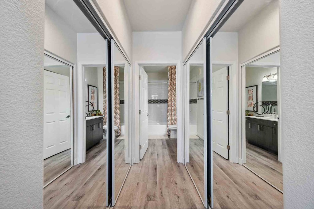 a spacious master bathroom with a hardwood flooring and white walls and ceiling. the room