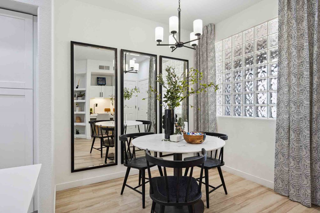 a small dining room with a round dining table and black chairs