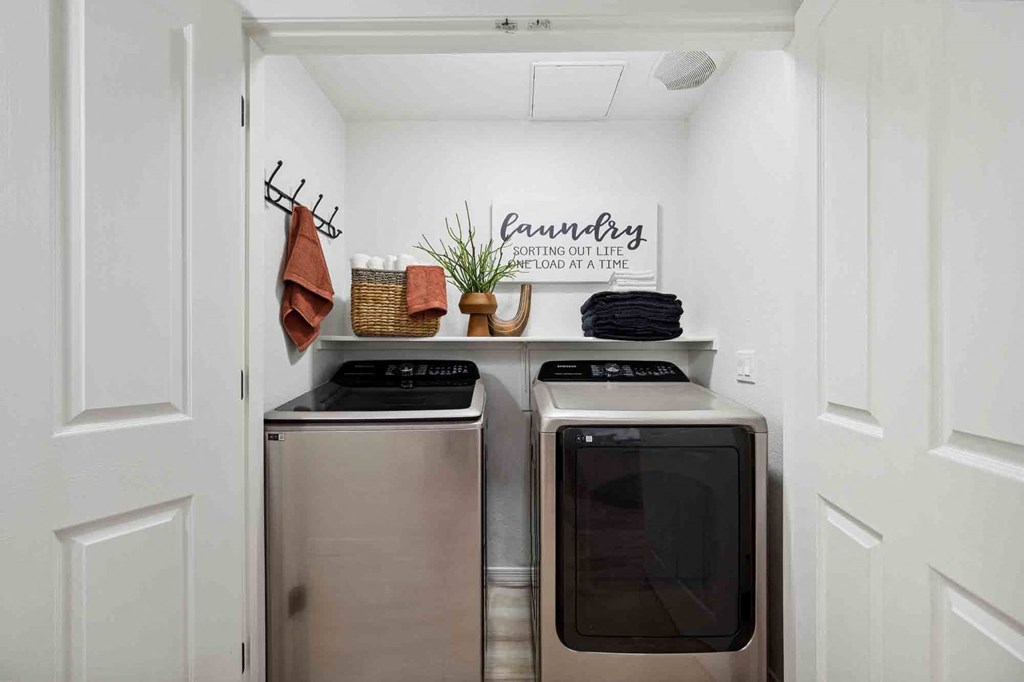 a laundry room with two washers and a dryer