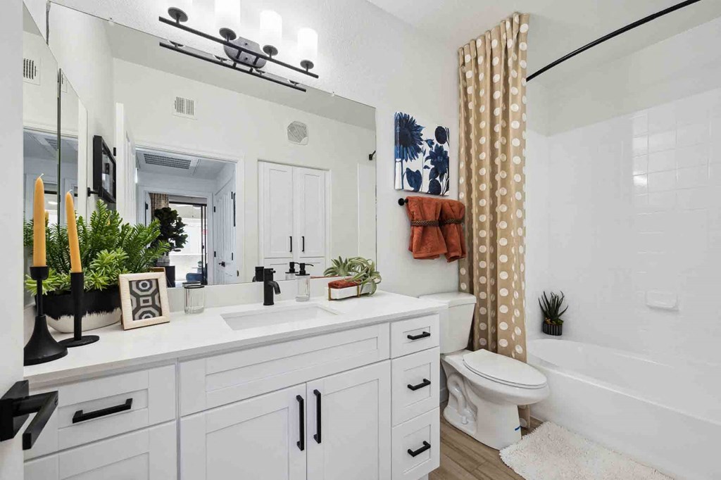 a bathroom with a white sink and toilet next to a bathtub with a shower curtain