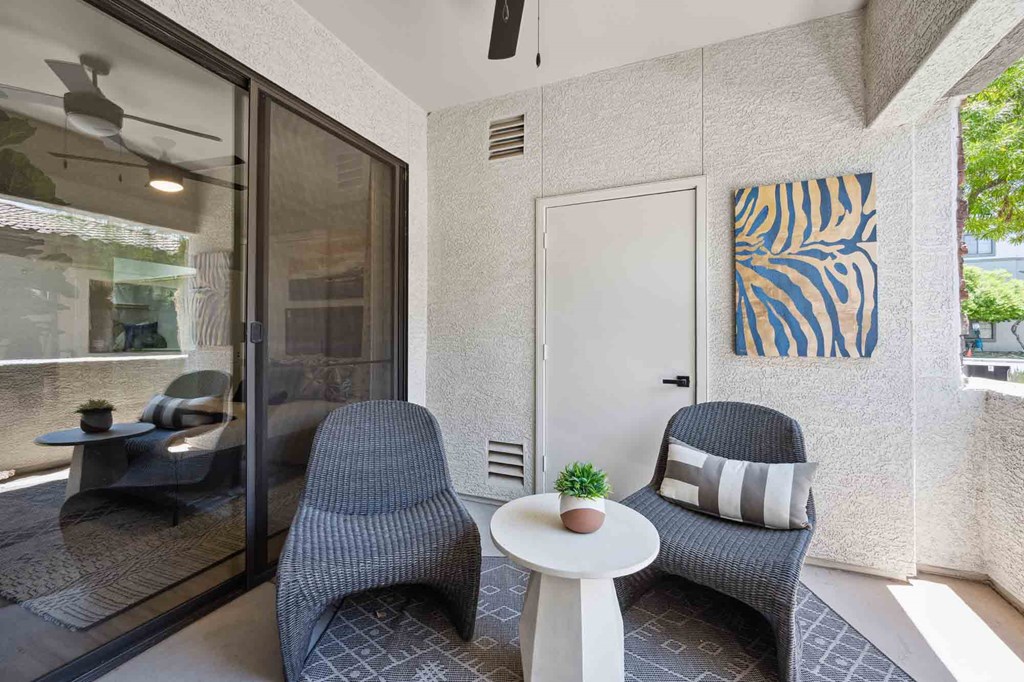 a patio with two chairs and a small table