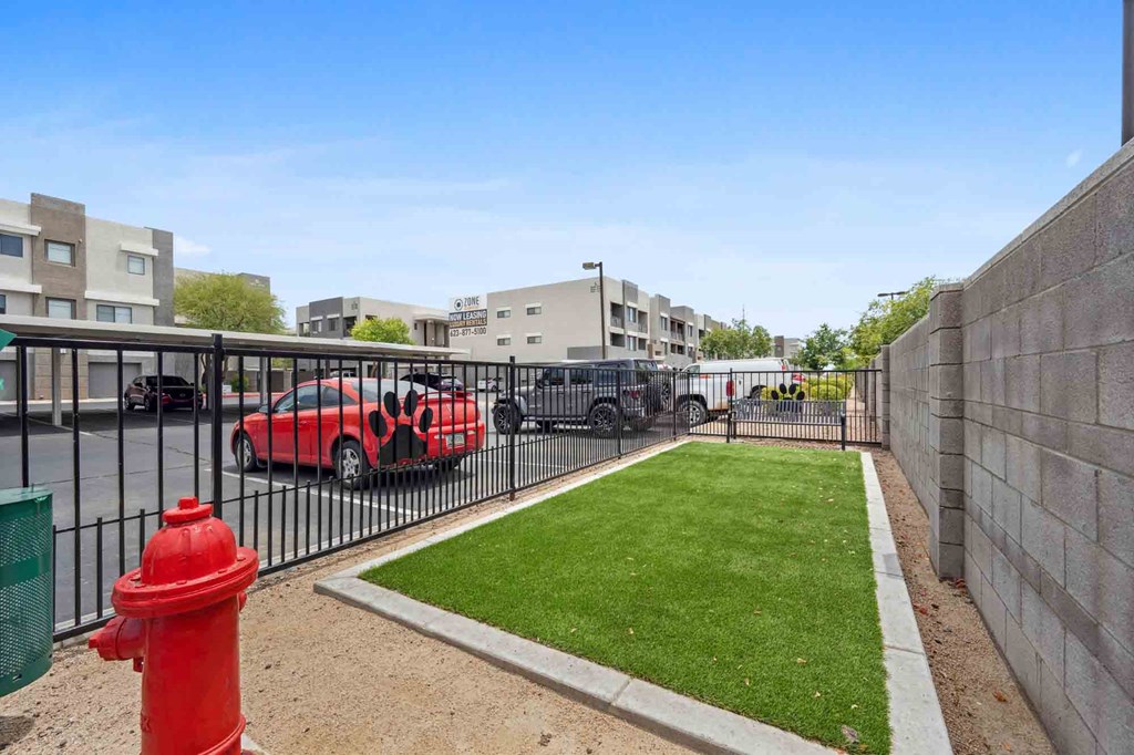 a fire hydrant sits on a small patch of grass in front of an apartment complex