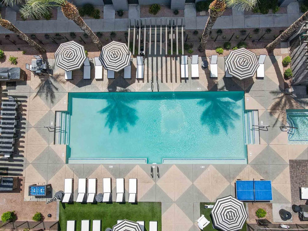 aerial view of a resort pool surrounded by lounge chairs and umbrellas