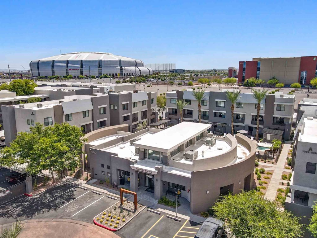 an aerial view of an apartment complex with a soccer stadium in the background